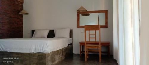 龙目岛库塔Mengalung Bungalow的一间卧室配有一张床、一把椅子和镜子