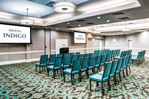 亚特兰大亚特兰大维宁斯爱达格酒店的一间会议室,配有蓝色椅子和讲台