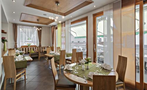 圣马蒂诺Hotel Pfandleralm的餐厅设有桌椅和窗户。