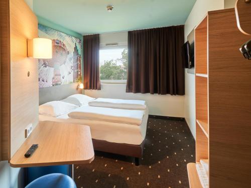 达姆施塔特达姆施塔特B&B酒店的酒店客房设有两张床和一张桌子。
