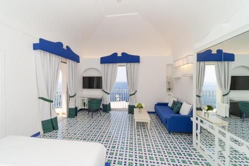 波西塔诺麦润科图酒店的一间卧室配有蓝色的床和蓝色的沙发