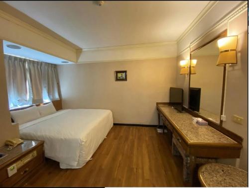 东港大鹏湾度假酒店的酒店客房,配有床和镜子