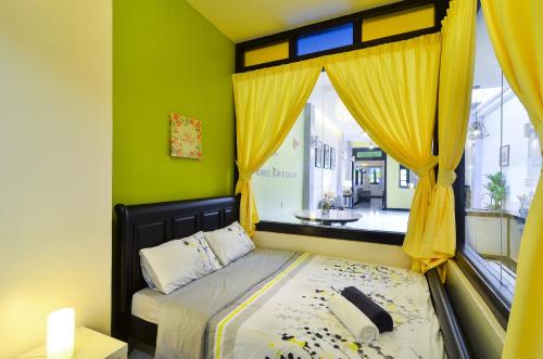 马六甲马六甲埃格顿别墅的一间卧室配有一张带黄色窗帘的床和一扇窗户