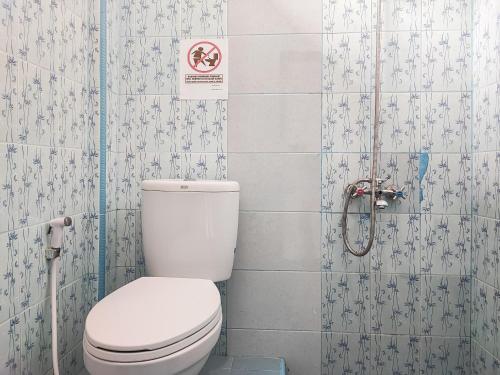 KinatiRedDoorz Plus Syariah near Simpang Rimbo Jambi的一间带卫生间的浴室和墙上的标志