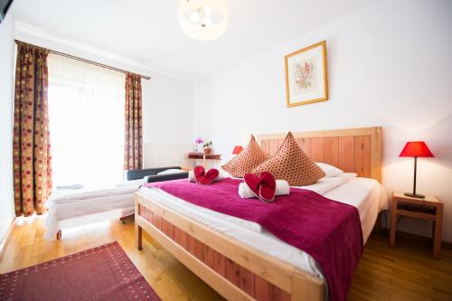 布什泰尼Pensiunea Turistica Villa Ermitage的一间卧室配有一张带红色枕头的大床