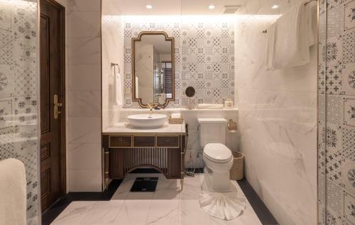 清迈CHINO@NIMMAN Luxury Boutique Hotel的一间带水槽、卫生间和镜子的浴室
