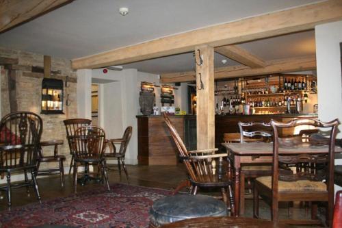 纳斯同Queen's Head Inn的一间带桌椅的用餐室和一间酒吧