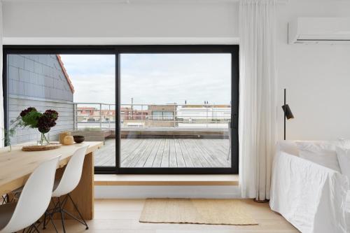 克诺克－海斯特Julias Rooftop stay的一间卧室设有一张桌子和一个大窗户