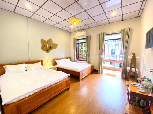 高平DH Homestay Cao Bằng的一间卧室设有两张床和窗户。