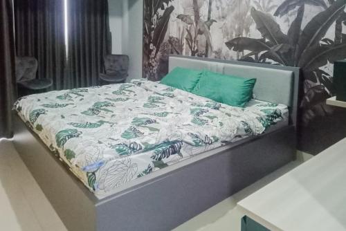 CikeasRedLiving Apartemen Royal Sentul Park - Budi Property的一张带绿色和白色棉被的床