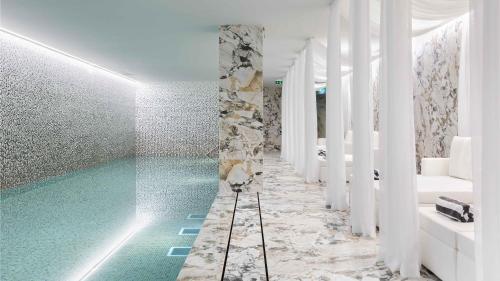 波尔图Wine & Books Porto Hotel的一间带绿松石游泳池的浴室