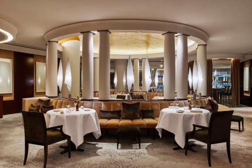 巴黎Park Hyatt Paris - Vendôme的一间带两张桌子和一张长沙发及椅子的餐厅