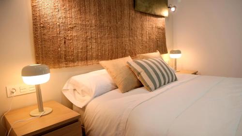 普拉森西亚HOTEL LOS ALAMOS BOUTIQUE的一间卧室配有一张带两盏灯的床和一扇窗户。