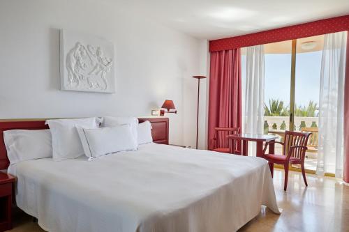 美洲海滩克里奥帕特拉皇宫酒店的卧室配有白色的床和桌椅