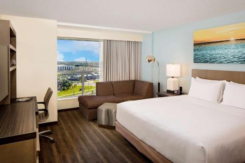 奥兰多奥兰多环球影城度假村对面凯悦嘉轩酒店的酒店客房设有床、沙发和窗户。