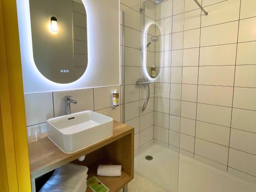 卡斯泰greet hotel Castets Coeur des Landes的白色的浴室设有水槽和淋浴。