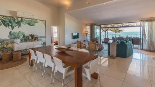 埃斯尼角天堂海滩地平线假期公寓式酒店的用餐室以及带桌椅的起居室。