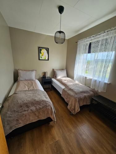海拉Skeiðvellir Villa的一间卧室设有两张床和窗户。
