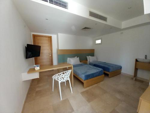 赫尔格达Nayah Stays, Ground terraces Studio的一间卧室配有两张床、一张桌子和一台电视。