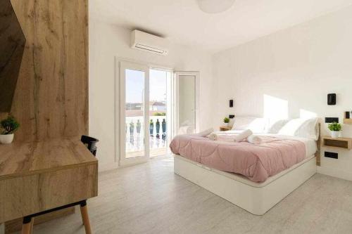 圣巴托洛梅Villa Sofía Maspalomas的白色的卧室设有床和大窗户