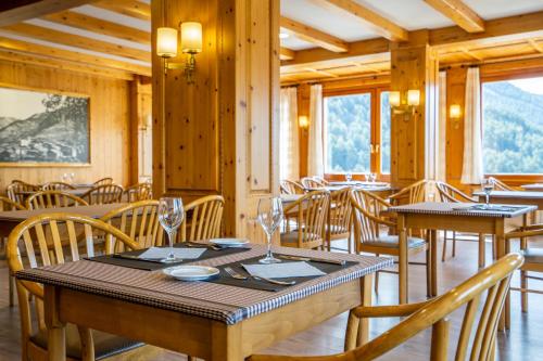 奥尔迪诺Abba Ordino Babot Hotel的用餐室设有桌椅和窗户。