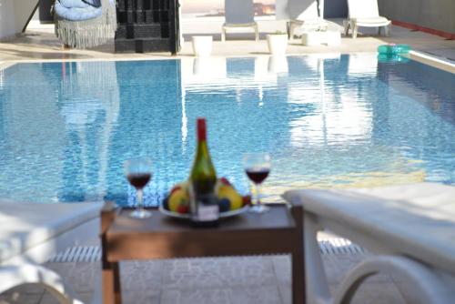 安塔利亚La Rezidans Hotel的游泳池旁的桌子上摆放着葡萄酒和水果