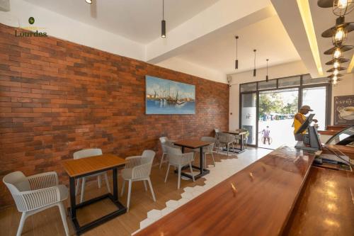 SiayaHotel Lourdes, Siaya的一间带桌椅的餐厅以及砖墙