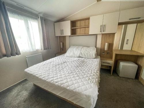 滨海克拉克顿Beautiful 6 Berth Caravan With Decking, Wifi And Field Views Ref 29029sv的一间卧室配有一张床、一张书桌和一个窗户。