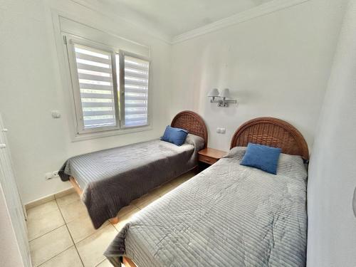 奥利瓦Apartamento Teresa的一间卧室配有两张带蓝色枕头的床