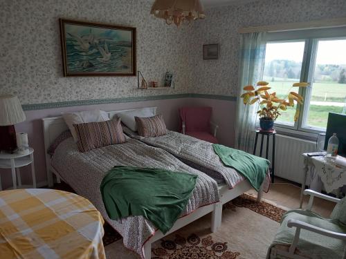 萨洛Vaskio-bed的一间卧室配有一张带绿色床单的床和一扇窗户。