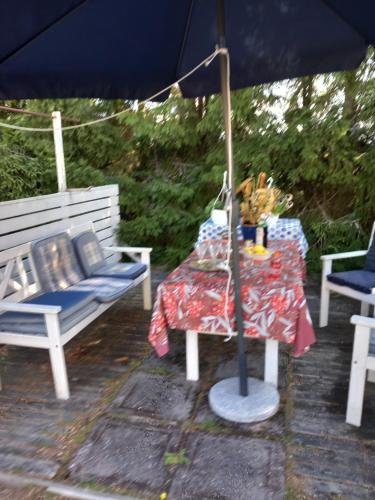 萨洛Vaskio-bed的一张桌子和一把遮阳伞,旁边是两把椅子