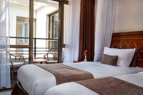 基苏木VICTORIA COMFORT INN的酒店客房设有两张床和一个阳台。