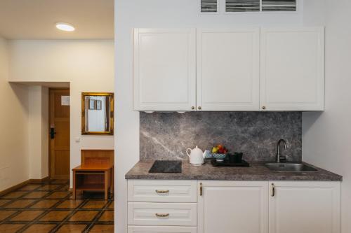 维尔纽斯CATHEDRAL HOTEL Self-check in的厨房配有白色橱柜和水槽