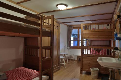 圣安特尼恩Gasthaus Bellawiese的客房设有两张双层床和盥洗盆。