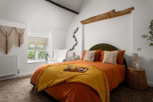 斯托昂泽沃尔德Stow Newly Remodeled Scandi Chic的一间卧室配有一张带橙色毯子的大床