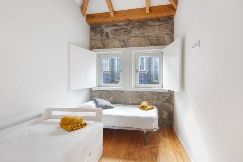 孔迪镇Lidador House Vila do Conde的一间卧室设有两张床和两个窗户。