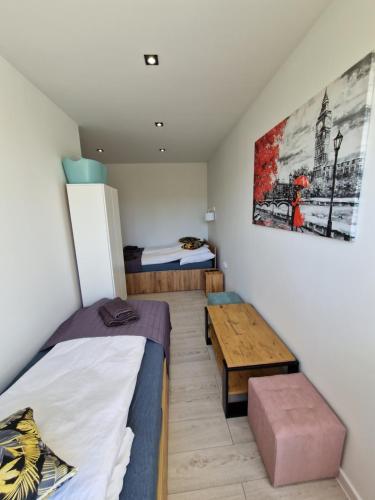 登比察YourSecondFlat Sobieski Apartment的一间设有两张床和一张桌子的房间