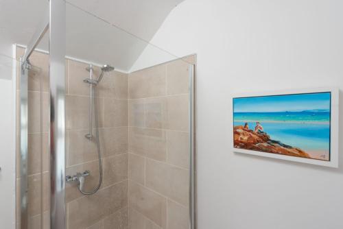 卡比斯贝Laity Vean Hideaway的带淋浴的浴室和墙上的电视