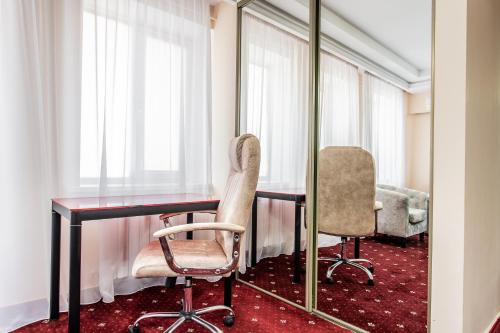 基希讷乌Star Rent Hotel的配有桌子、两把椅子和镜子的房间