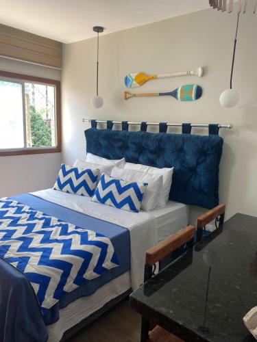 维拉维尔哈Suíte Itaipu Mar的一间卧室配有两张带蓝白色床单的床