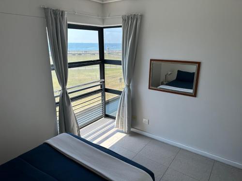 德班Point Beach #Accommodation - Durban Beach & Waterfront Canals EPIC VIEWS的一间卧室设有一张床和一个大窗户