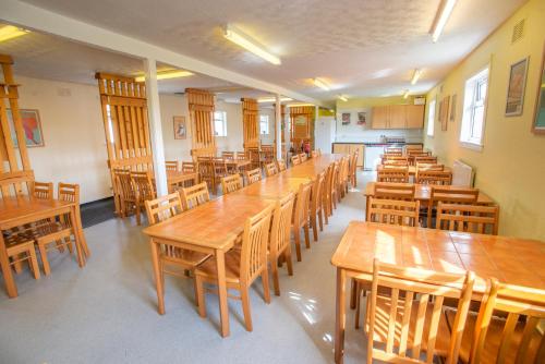 柯克沃尔Kirkwall Youth Hostel的配有木桌和木椅的教室