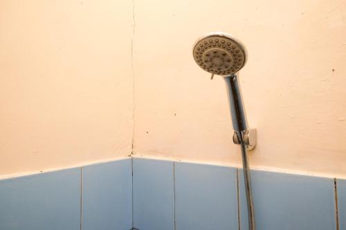SeturanRedDoorz near Plaza Ambarrukmo Yogyakarta的浴室的墙上设有淋浴头