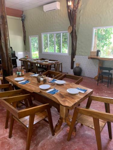 Krua Chehe Resort ครัวเจ๊ะเห รีสอร์ท的一间带木桌和长凳的用餐室