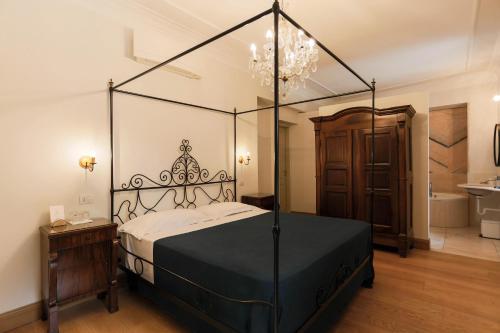 坎特洛麦当娜餐厅酒店的一间卧室配有一张带吊灯的黑色天蓬床