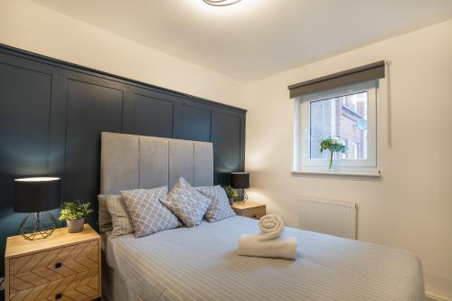 爱丁堡Modern 2BED Apartment-Free Parking的一间卧室配有一张带大型黑色床头板的床