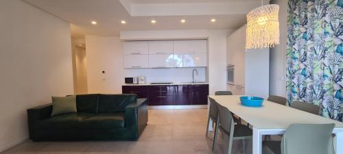 马斯卡利Villa sul mare Dambra Apartment的厨房以及带桌子和沙发的客厅。