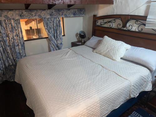 圣贝纳迪诺Country San Bernardino的卧室配有白色的床和木制床头板