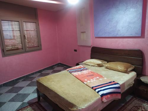 坦坦شقق فندقية بن خليل /hôtel appartements Bin khlil的一间卧室设有两张床和粉红色的墙壁