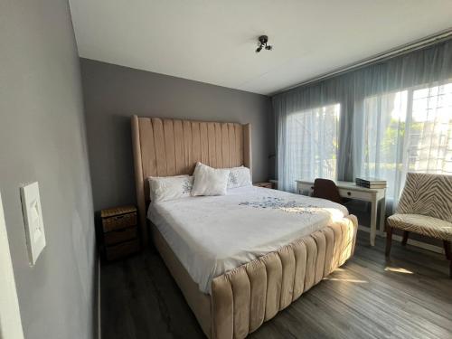 鲁德普特Royal Retreat的一间卧室配有一张大床和一把椅子